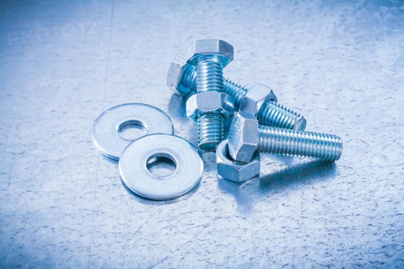 Metal threaded screws Nuts and bolts Washers on metallic background Construction concept