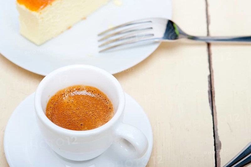 Italian espresso coffee and cheese cake over white wood table