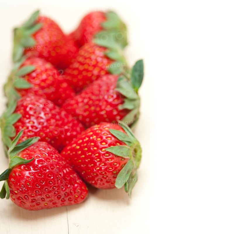 Fresh organic strawberry over white rustic wood table