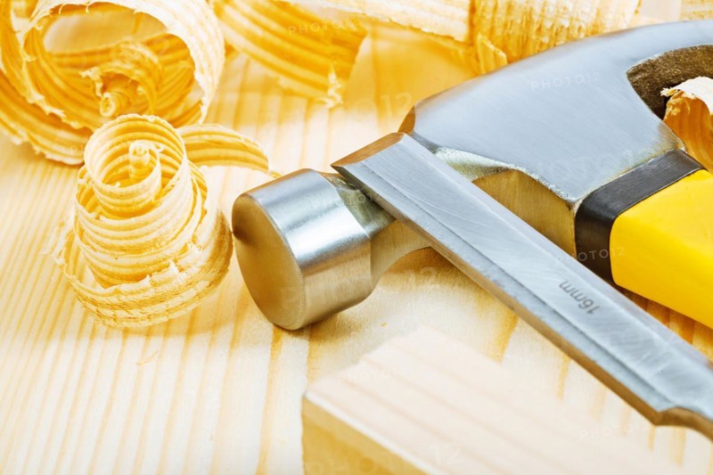 Carpenter's chisel on hammer and boards