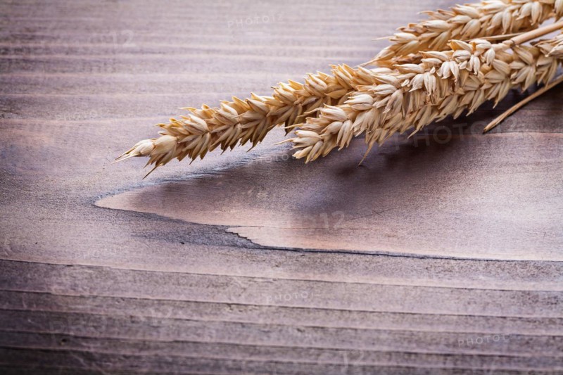 Ears of rye on vintage wooden board food and drink concept
