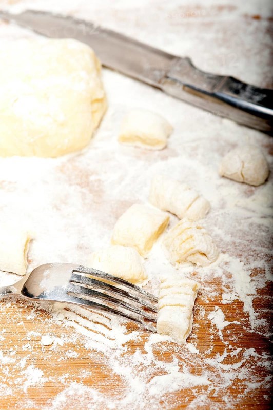 Making fresh Italian potato gnocchi on a wood rustic table