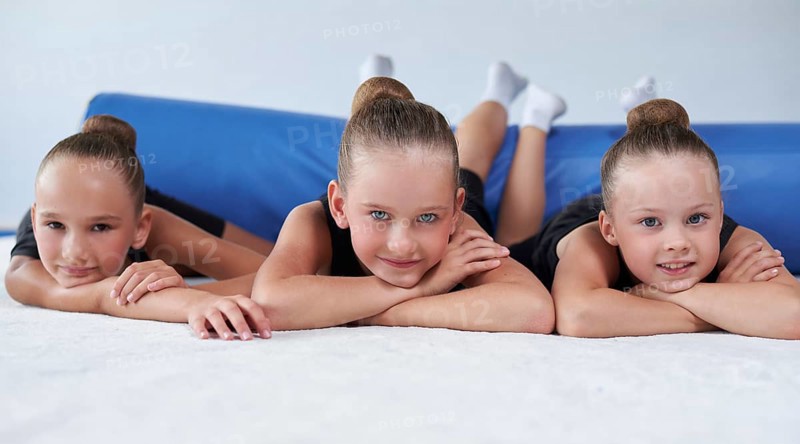 Image of a group of little girls in the gym after a workout. Gymnastics concept. Mixed media
