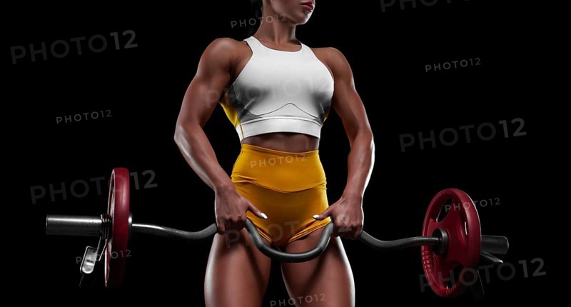 Fitness girl doing exercises with a barbell in the gym. Bodybuilding concept. Mixed media