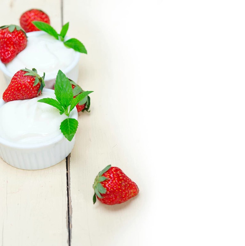 Organic Greek yogurt and strawberry over white rustic wood table