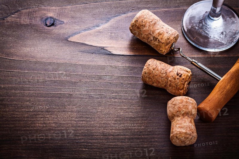 Champagne corks and corkscrew on vintage wooden board with copying area