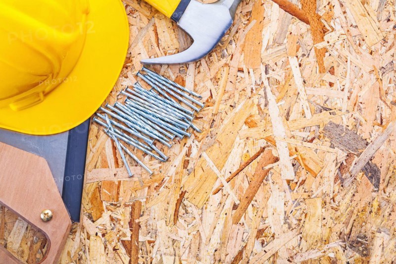 Construction tool helmet hand saw claw hammer nails on plywood horizontal version
