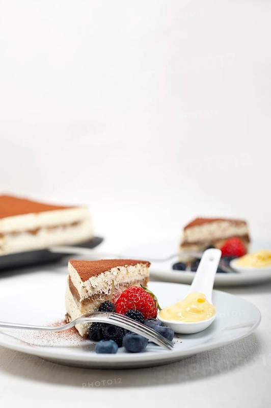 Classic Italian tiramisu dessert with berries and custartd pastry cream on side