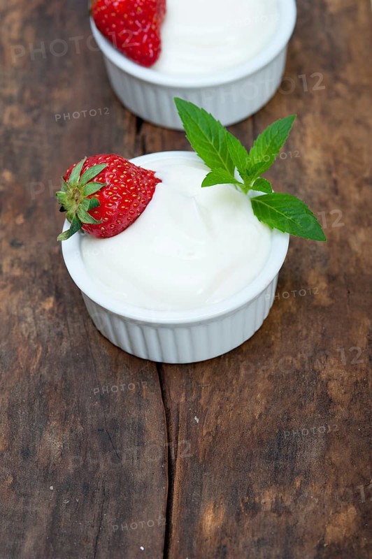 Organic Greek yogurt and strawberry on a rustic wood table