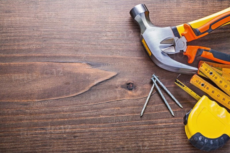 Copyspace image claw hammer nails tapeline wooden metre pliers on vintage board building concept