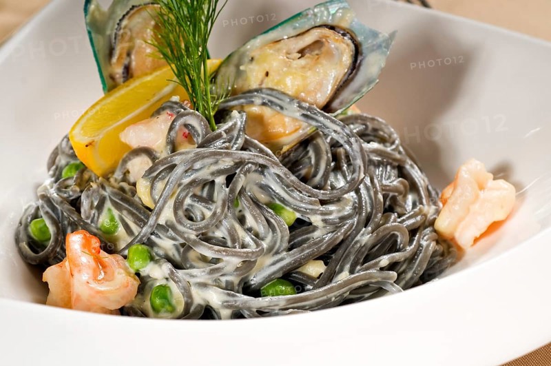 Fresh seafood black squid ink coulored spaghetti pasta tipycal italian food