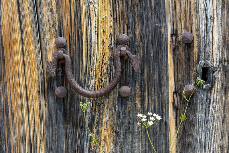 Old wooden door with aged metal door handle. Architectural textured background