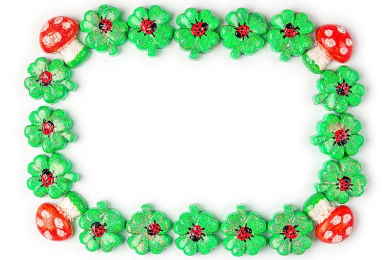 A frame of shamrocks with ladybirds and toadstools