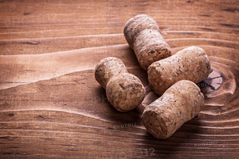 Four corks of champagne on an old wooden board
