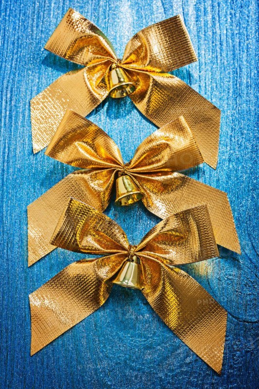 Composition of golden arches with bells painted on old blue colour wooden board