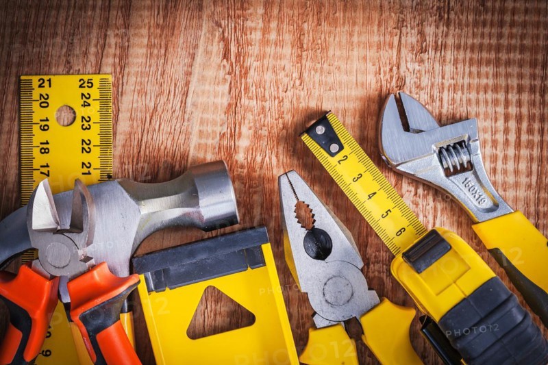 Hand tools spanner tapeline pliers level hammer pliers ruller on vintage wooden board construction concept