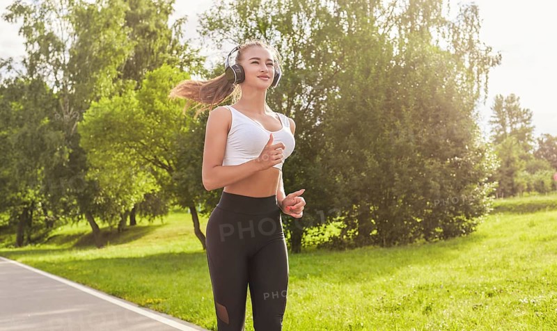 Fitness girl in sportswear runs through the evening sunny park. Healthy lifestyle. Mixed media