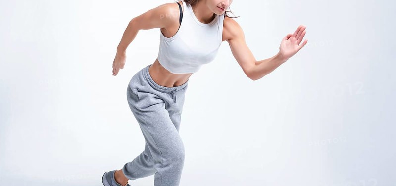 No name portrait. Sports woman runner on a white background. Photo of an attractive woman in fashionable sportswear. Dynamic movement. Side view. Sports and healthy lifestyle. Mixed media