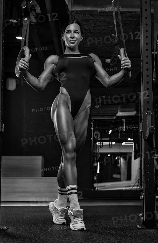 Black and white image of a sexy fitness woman. A beautiful sportswoman is training in the gym. Mixed media