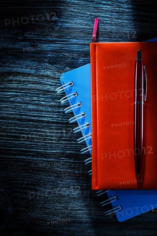 Composition of pocketbooks pen on wooden board