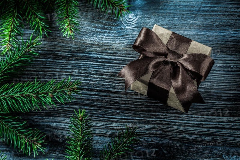Brown present box pine branches on wooden board