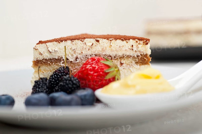 Classic Italian tiramisu dessert with berries and custartd pastry cream on side