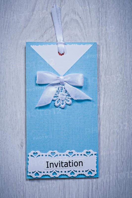 Blue invitation envelope on a grey background