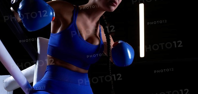 Noname photo of an athletic busty woman in a boxing ring. The concept of sports and mixed martial arts