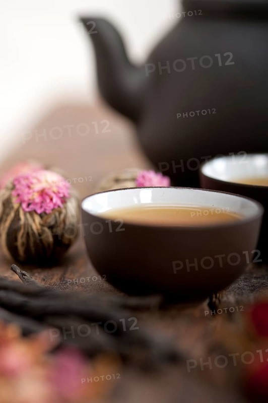 Chinese style herbal floral tea over wood table with raw ingredients