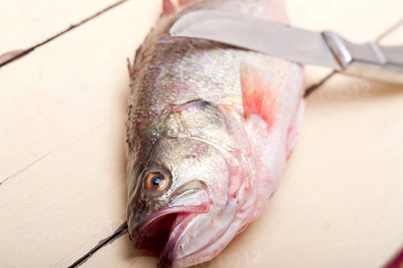 Fresh whole raw fish on a wooden table ready to cook