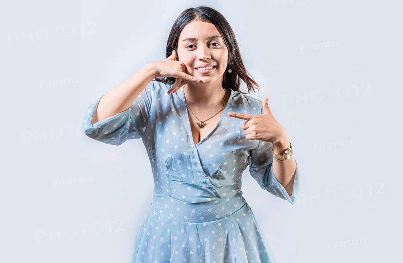 Young woman gesturing CALL ME in sign language isolated. Manual gestures of people with hearing problems