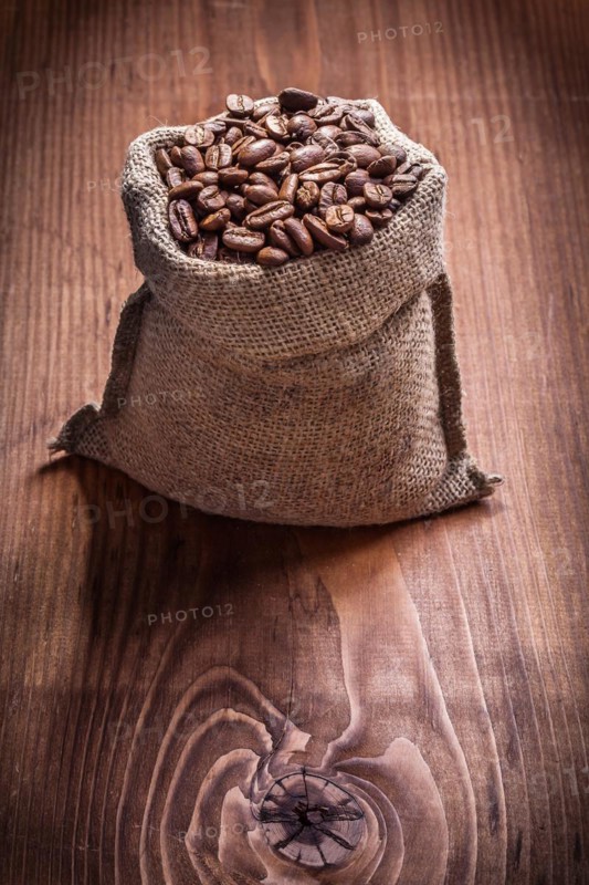 Bag of coffee beans on an old wooden board
