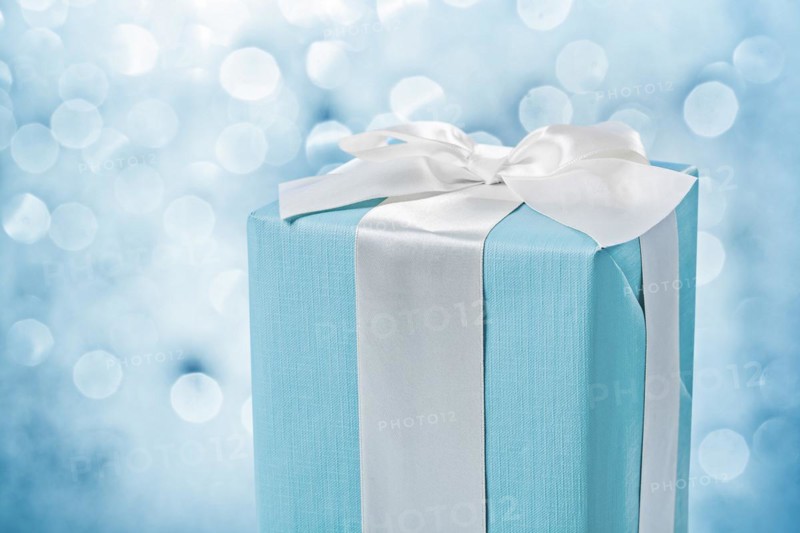 Close up view blue gift box with white bow on blurred background