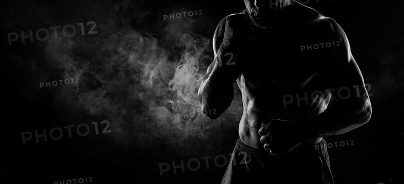 Noname image of a kickboxer on a dark background. The concept of mixed martial arts. MMA