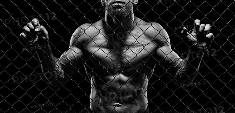 Black and white image of a man in a boxing cage. The concept of sports