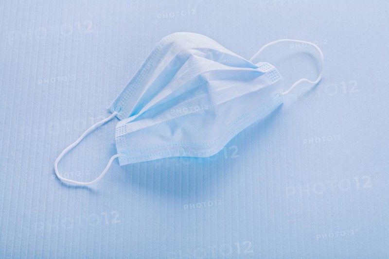 Disposable face mask on a blue background