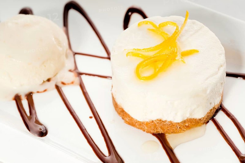 Very elegant lemon mousse dessert served whith lemon peel on top and vanilla ice cream on side