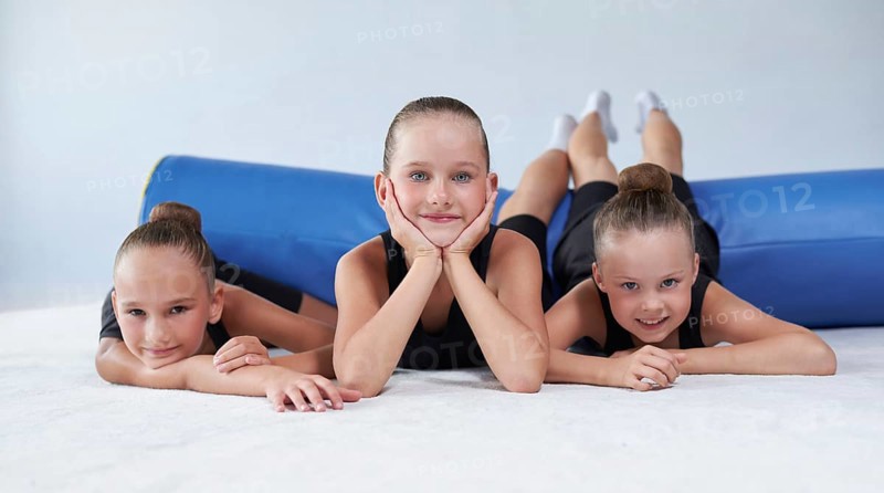 Image of a group of little girls in the gym after a workout. Gymnastics concept. Mixed media