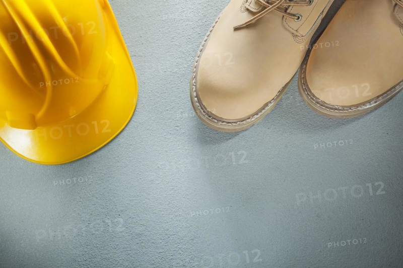 Hard hat waterproof safety boots on concrete background