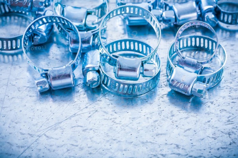 Composition of metal spiral hose clamps on a metallic background Design concept