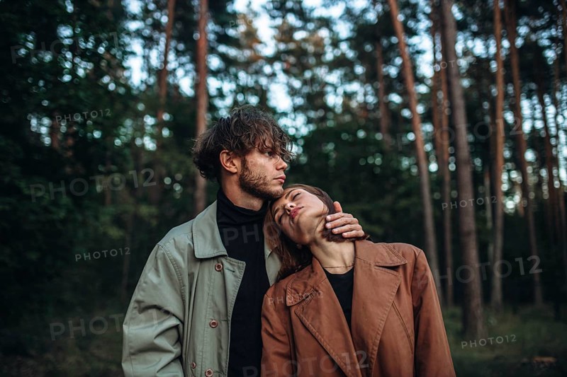 Romantic couple of lovers on a date in the park in cold weather. Fashionable couple in coat