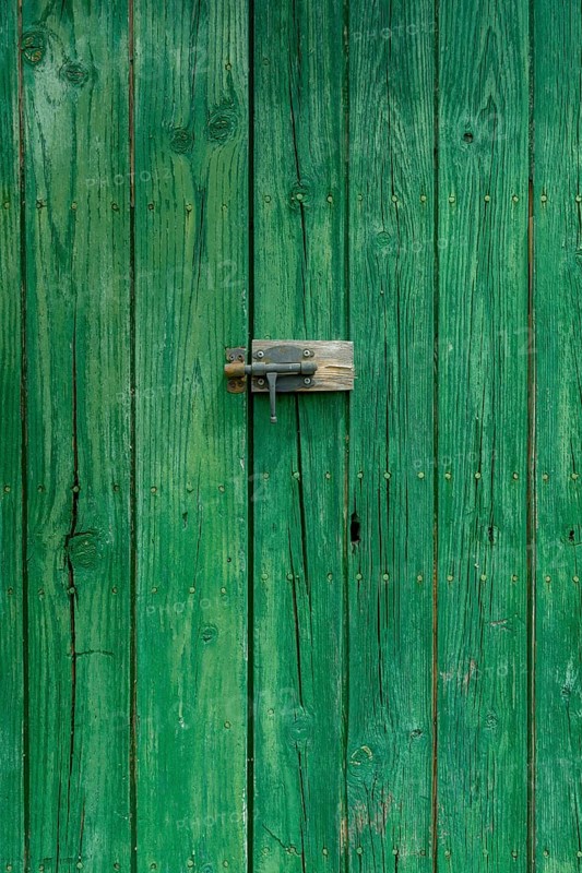 Old wooden door with aged metal door handle. Architectural textured background