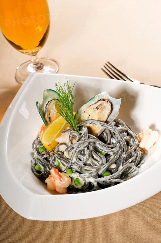 Fresh seafood black squid ink coulored spaghetti pasta tipycal italian food