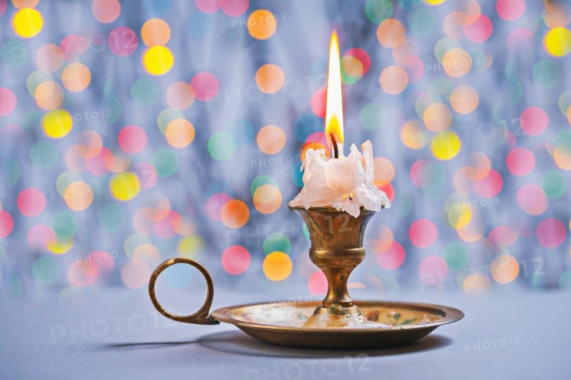 Gloving candle in vintage candlestick on background of bokeh