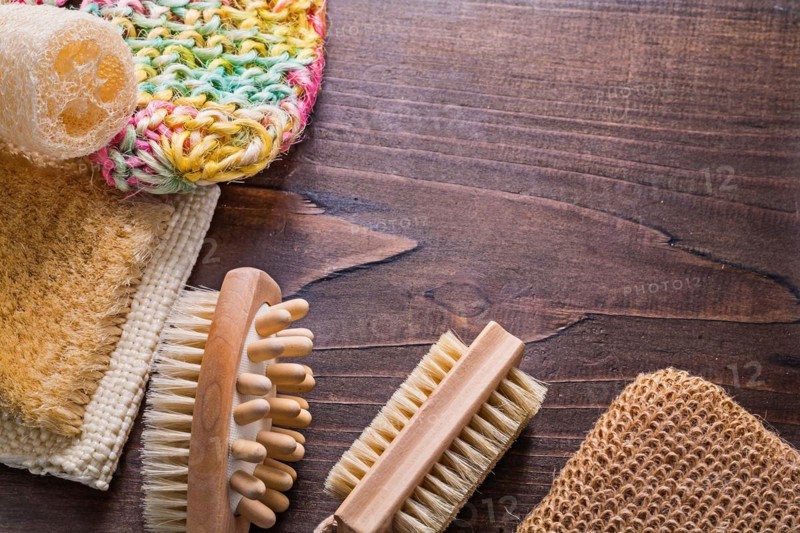Bath sticks loofah massagers on vintage wooden board with copy area