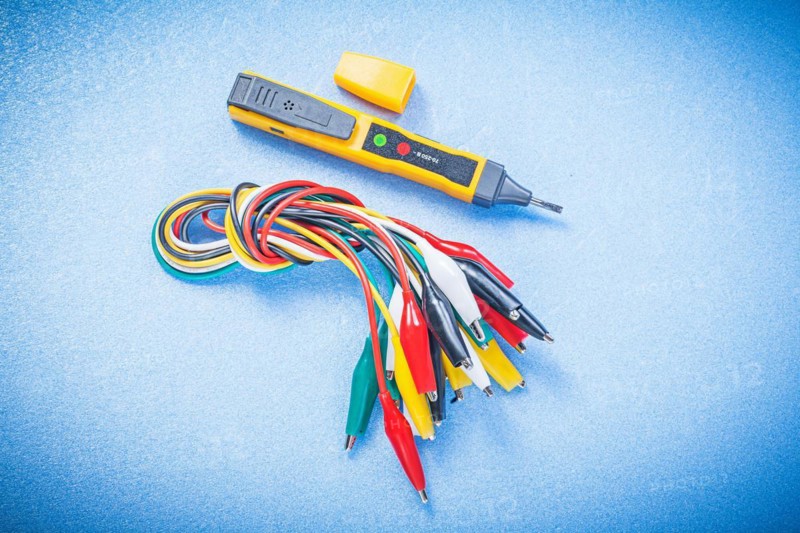Electrical tester indicator crocodile plugs on blue background electricity concept