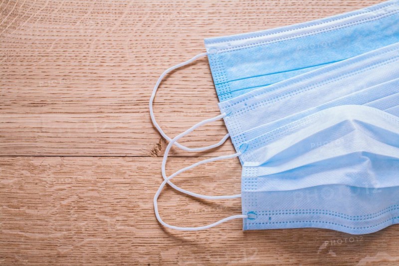 Blue disposable face masks on wooden board medical concept