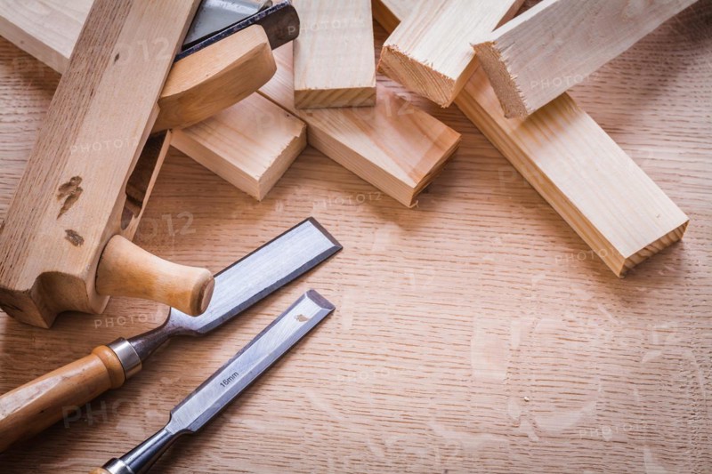 Chisel Woodworker Plane and planks on wooden board