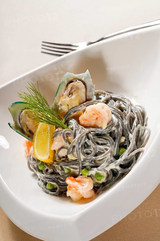 Fresh seafood black squid ink coulored spaghetti pasta tipycal italian food