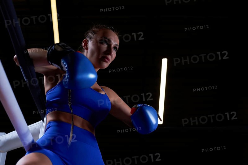 Powerful charged girl stands in the corner of the ring and is ready to explode in the next round. The concept of wrestling and boxing. Mixed media